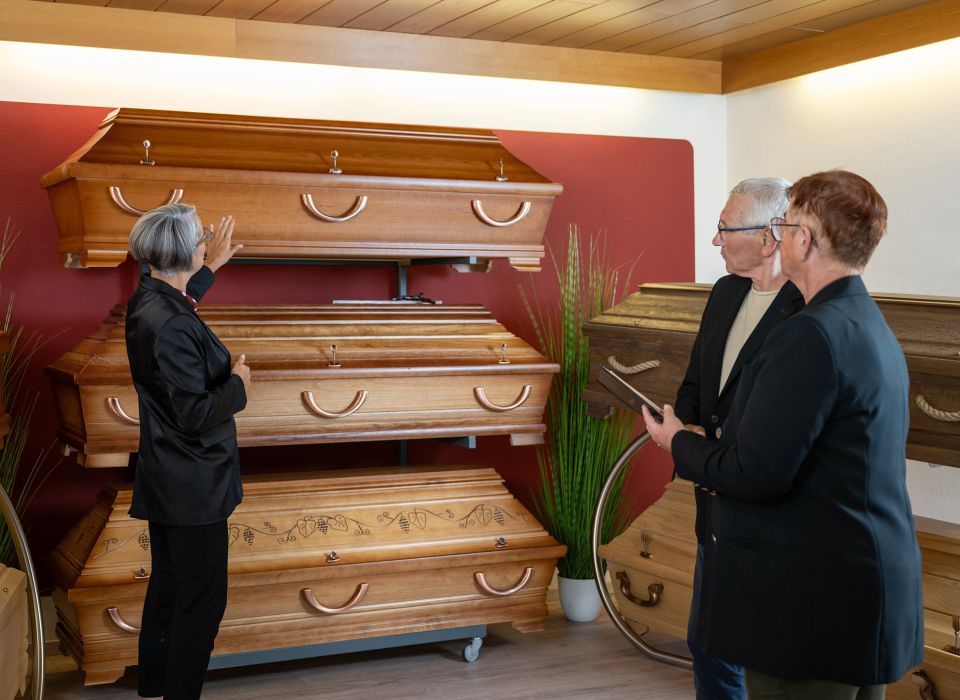 Janet Tarin zeigt auf eine Auswahl Särge